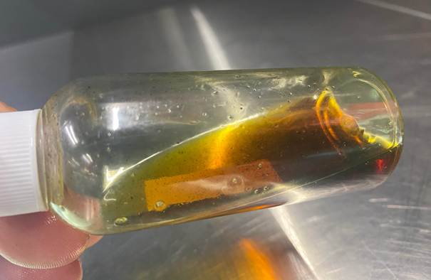 Fotobijschrift: Troebele olie door vochtopname en metaaldeeltjes door slijtage van de compressor